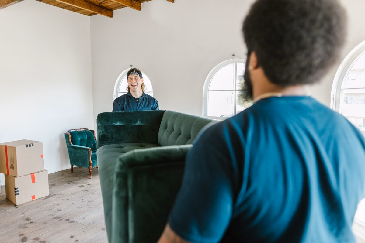 Movers carrying a couch out of a home